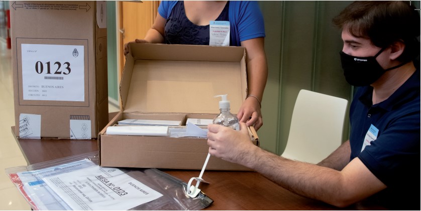 Hombre y mujer preparando los materiales de la mesa electoral
